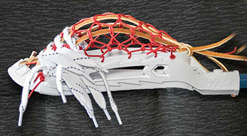 Close-up of a lacrosse head with white strings and red accents on a dark background