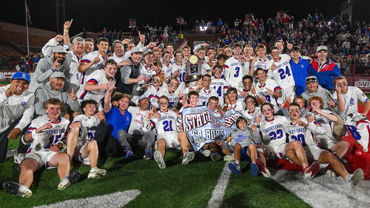 Team photo of a Cherry Creek Lacrosse boys team on the field with a championship banner.